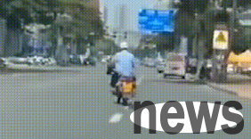 A man wearing what looks like a police uniform is dragging a puppy on a motorcycle. Is he pretending to be ignorant or is he really being abused?